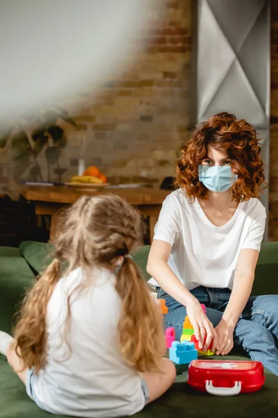 엄마가 의료용 마스크를 아이를 초점을 맞추고 — 스톡 사진
