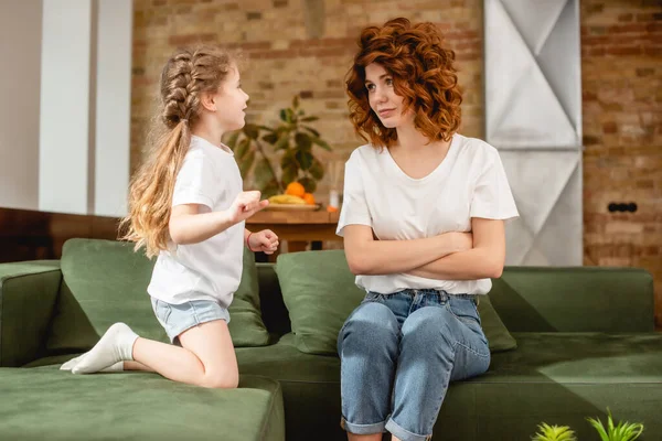 Cute Kid Looking Curly Mother Crossed Arms Sitting Sofa — Stock Photo, Image