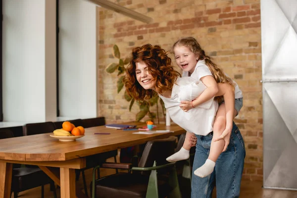 Happy Curly Mother Piggybacking Cute Daughter — Stock Photo, Image