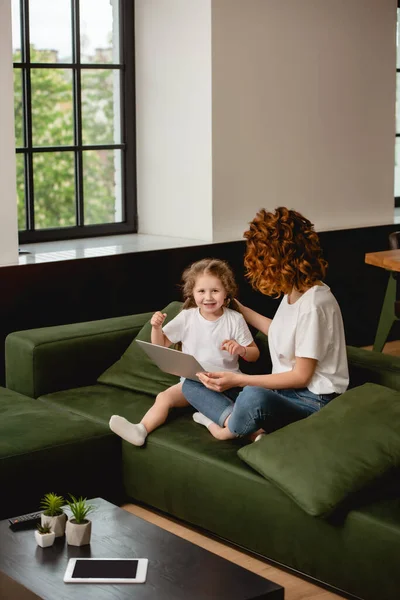 Mama Creț Care Deține Laptop Lângă Fiica Fericită Camera — Fotografie, imagine de stoc