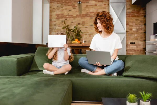 Redhead Freelancer Utilizzando Laptop Vicino Figlia Faccia Copertura Con Tablet — Foto Stock