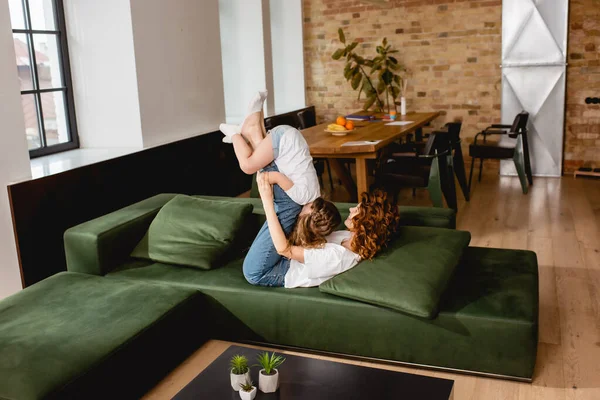 Curly Mother Lying Sofa Lifting Cute Child Living Room — Stock Photo, Image