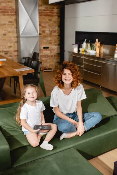 Cute Kid Holding Remote Controller Sitting Redhead Mother Sofa — Stock Photo, Image