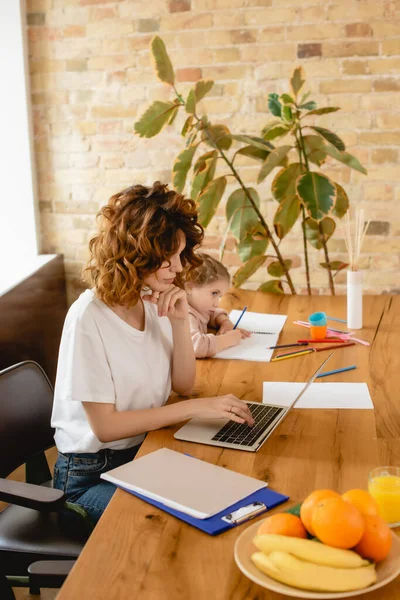 Freelancer Moeder Met Behulp Van Laptop Terwijl Leuke Dochter Tekening — Stockfoto