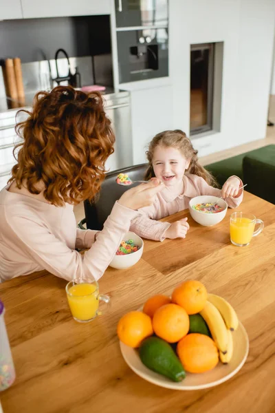 Curly Mother Happy Daughter Holding Spoons Bowls Corn Flakes Glasses — Stock Photo, Image