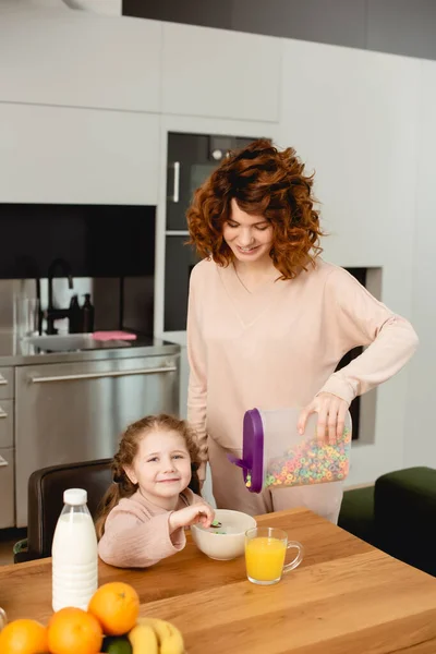 Happy Mother Holding Container Corn Flakes Cheerful Daughter Kitchen — Stock Photo, Image