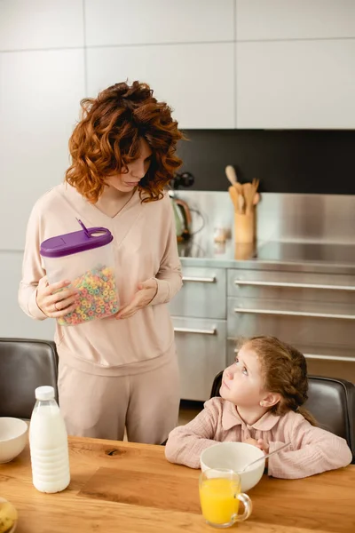 Schattig Kind Zoek Naar Moeder Holding Container Met Cornflakes — Stockfoto