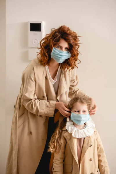 Pelirroja Rizada Madre Gabardina Usando Máscara Médica Linda Hija — Foto de Stock