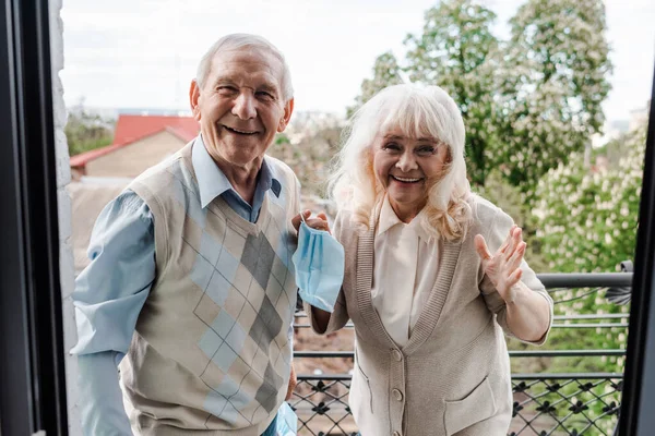 Feliz Casal Idosos Segurando Máscaras Médicas Enquanto Varanda Após Auto — Fotografia de Stock