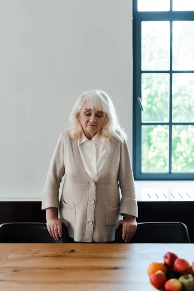Zdenerwowana Samotna Starsza Kobieta Stojąca Przy Stole Owocami Podczas Kwarantanny — Zdjęcie stockowe
