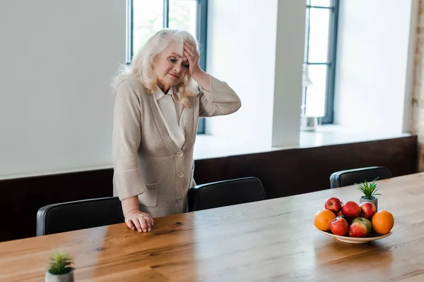 Mulher Idosa Cansada Com Dor Cabeça Mesa Com Frutas Durante — Fotografia de Stock