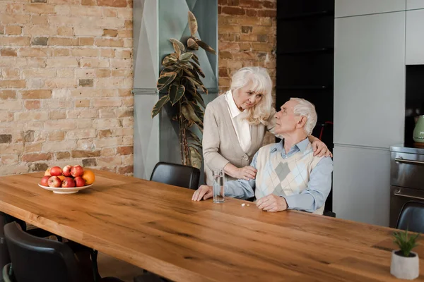 Triste Esposa Anciana Marido Enfermo Con Pastillas Vaso Agua Casa — Foto de Stock