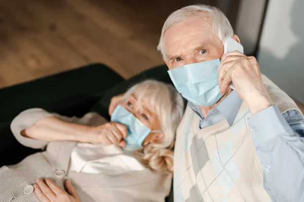 Ηλικιωμένος Άνδρας Ιατρική Μάσκα Καλεί Τον Γιατρό Smartphone Ενώ Άρρωστη — Φωτογραφία Αρχείου