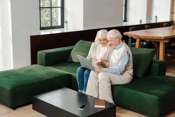 在自我隔离期间 一对快乐的老夫妇在家里的笔记本电脑上视频聊天 — 图库照片