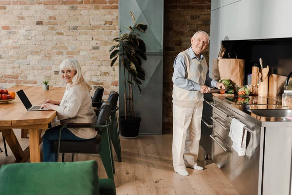 Счастливый Старший Муж Приготовления Пищи Время Жена Помощью Ноутбука Кухне — стоковое фото