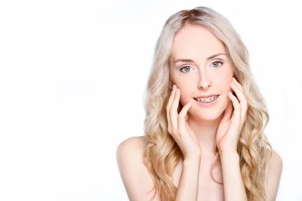 Woman with braces touching face — Stock Photo