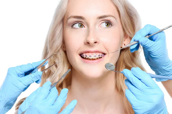 Mani che tengono gli strumenti dentisti vicino alla donna — Foto stock