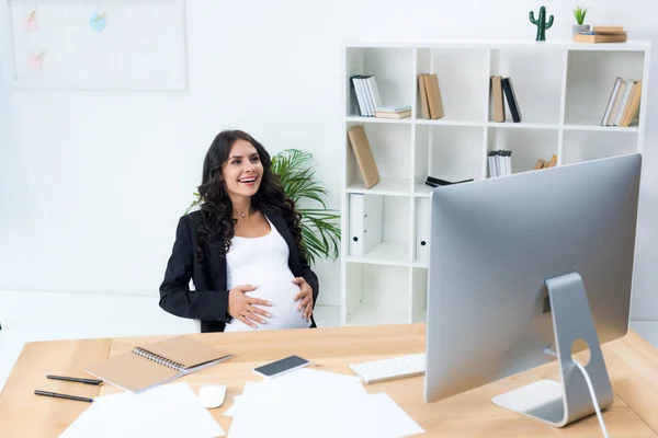 Embarazada mujer de negocios tocando su barriga - foto de stock
