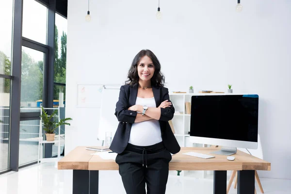 Femme d'affaires enceinte avec les bras croisés — Photo de stock