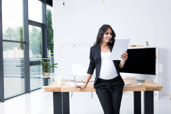 Pregnant businesswoman with paperwork — Stock Photo