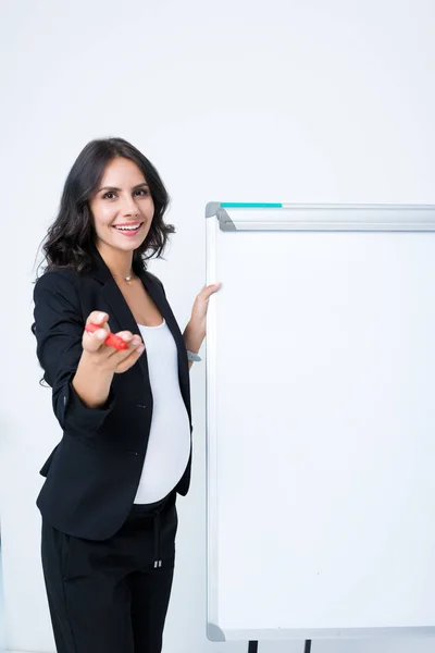 Pregnant businesswoman with blank whiteboard — Stock Photo