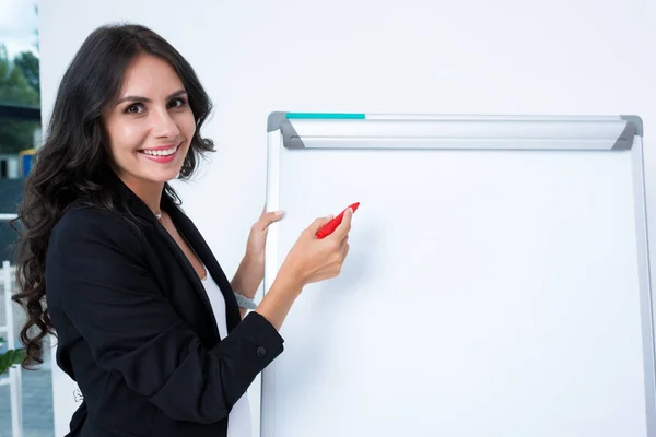 Pregnant businesswoman writing on whiteboard — Stock Photo