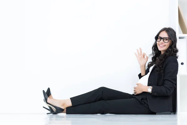 Pregnant businesswoman showing okay sign — Stock Photo