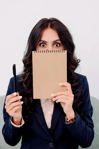 Business woman covering face with notepad — стоковое фото