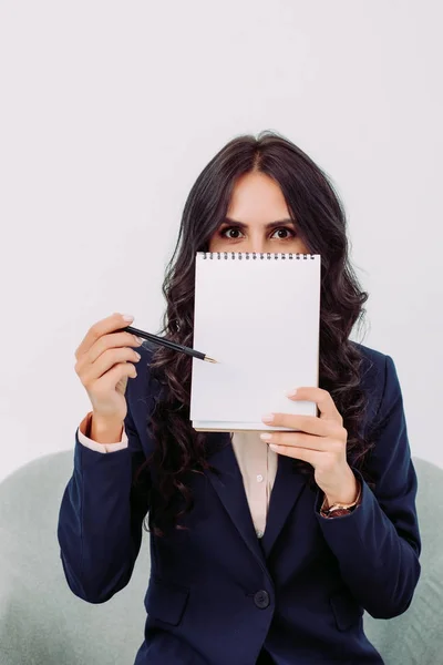 Empresária cobrindo rosto com bloco de notas — Fotografia de Stock