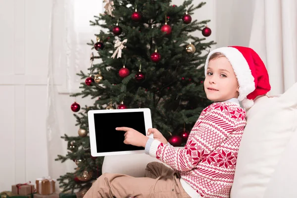 Chico apuntando a la tableta en Navidad - foto de stock