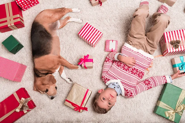 Junge mit Beagle-Hund und Weihnachtsgeschenken — Stockfoto