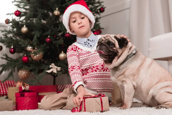 Ragazzo con regalo di Natale e carlino — Foto stock