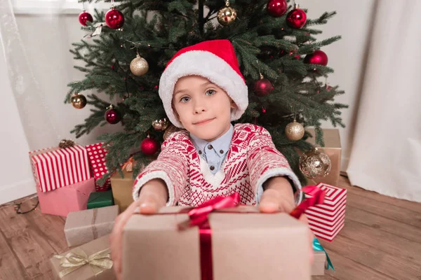 Junge verschenkt Weihnachtsgeschenk vor Kamera — Stockfoto