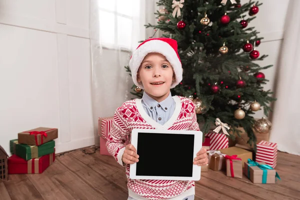 Junge im Weihnachtsmannhut mit Tablette — Stockfoto
