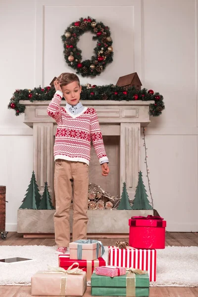 Мальчик, глядящий на кучу подарков — стоковое фото