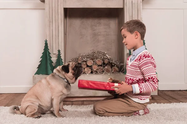 Boy presenting gift to dog — Stock Photo