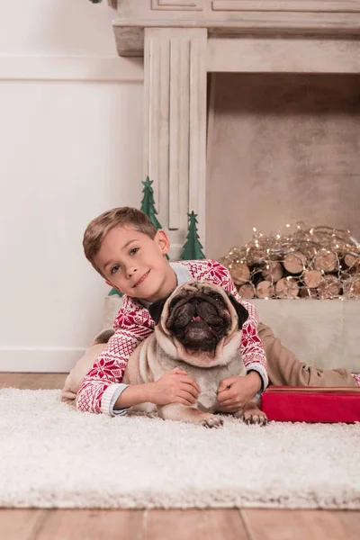Niño con regalo de Navidad y pug - foto de stock
