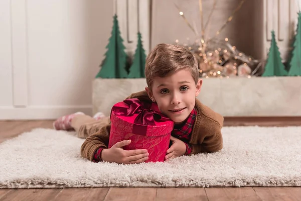 Ragazzo posa sul pavimento con regalo — Foto stock