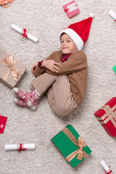 Ragazzo su tappeto con regali di Natale — Foto stock