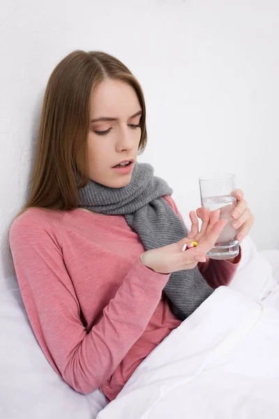 Femme avec de l'eau et médicaments — Photo de stock