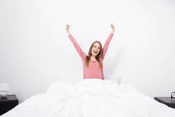 Mujer estirándose en la cama - foto de stock