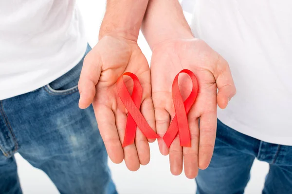 Gay couple holding aids ribbons — Stock Photo