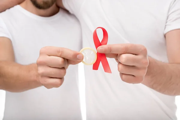 Gay couple with aids ribbon and condom — Stock Photo