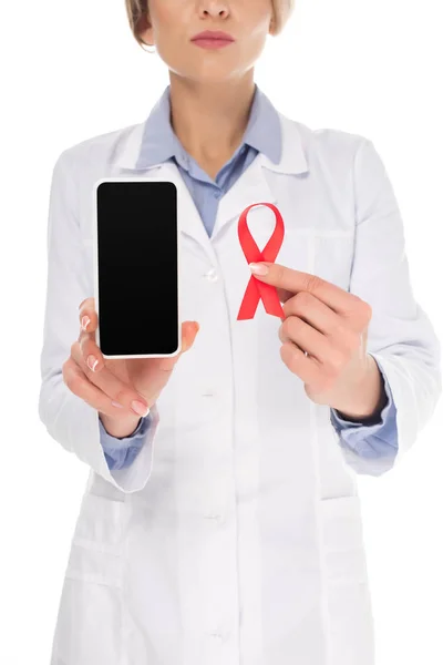 Doctor with smartphone and aids ribbon — Stock Photo