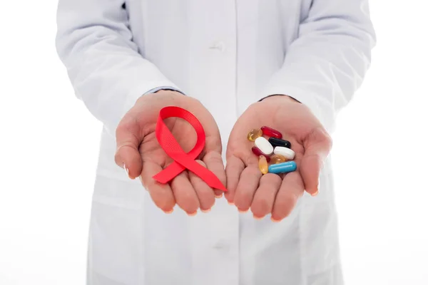 Врач со СПИДом лентой и таблетками — стоковое фото