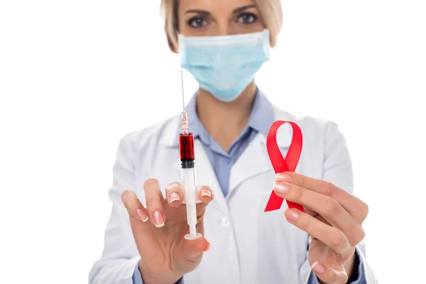 Doctor with syringe and aids ribbon — Stock Photo