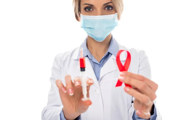 Doctor with syringe and aids ribbon — Stock Photo