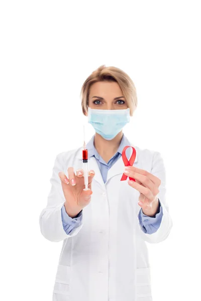 Doctor with syringe and aids ribbon — Stock Photo