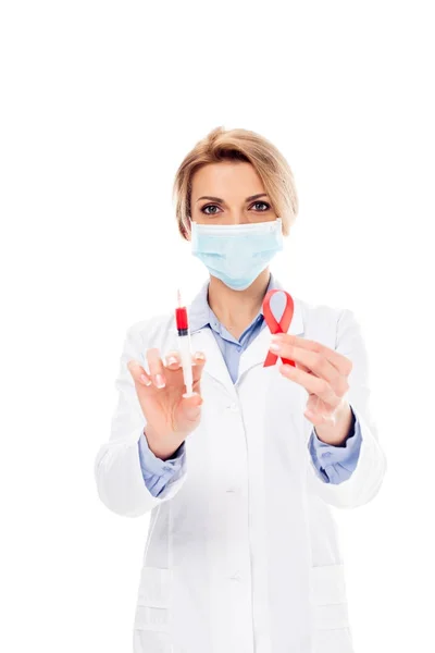 Doctor with syringe and aids ribbon — Stock Photo