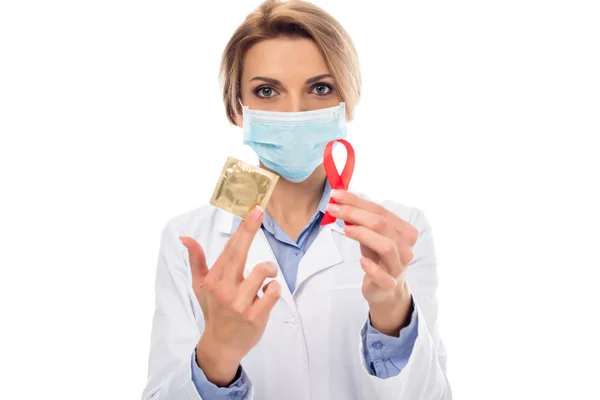 Médico con cinta de SIDA y condón - foto de stock